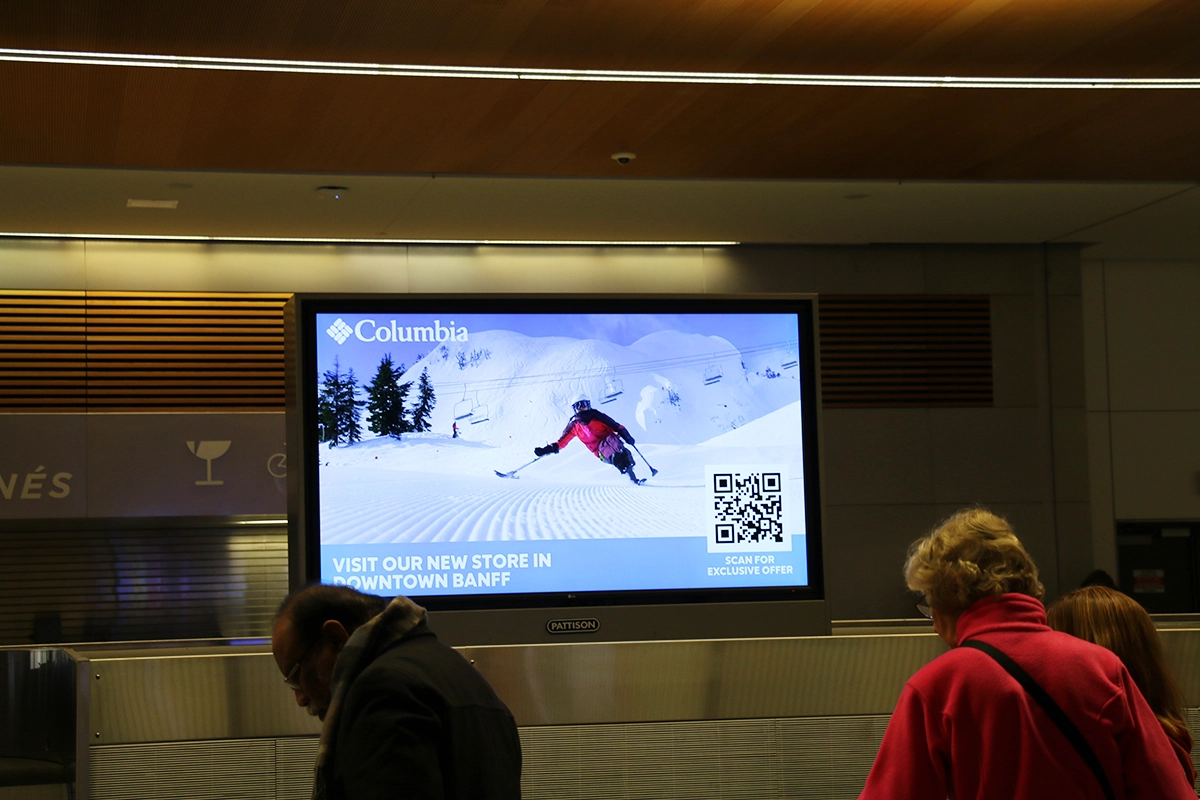 Digital screen displaying QR code in airport Out-of-Home advertising COLUMBIA SPORTSWEAR